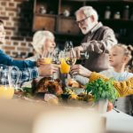beautiful family clinking glasses on holiday dinner- taxi landskrona trafiken önskar er trygga och säkra lov