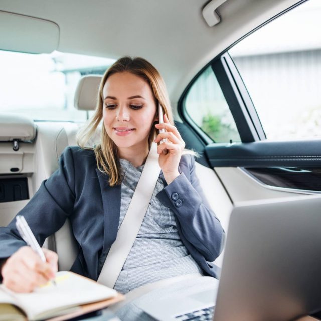Business woman with smartphone and laptop sitting on back seats in taxi car. Business woman with smartphone and laptop sitting on back seats in taxi car.-företagskund boka och beställ taxi landskrona trafiken 620