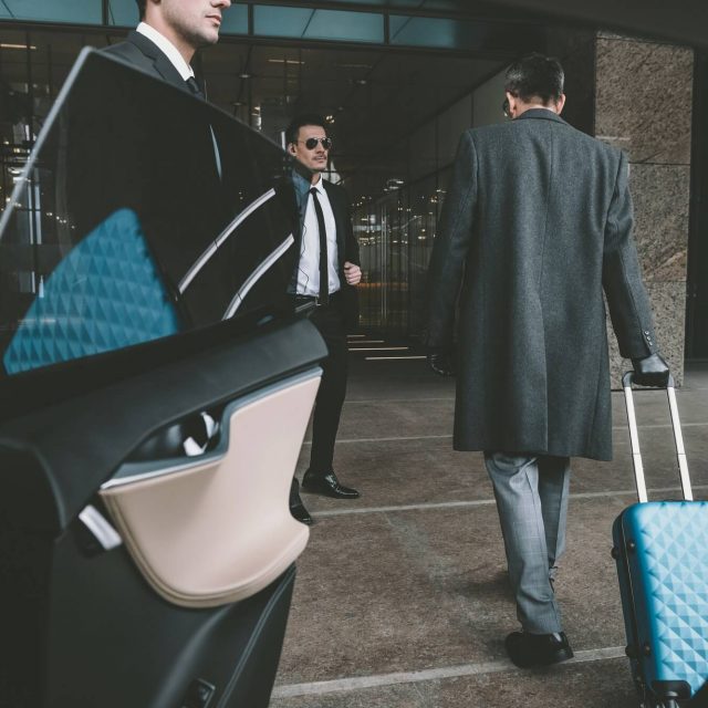 businessman going with blue bag on wheels to airport businessman going with blue bag on wheels to airport affärsman med blå resväska till flygplats taxi620